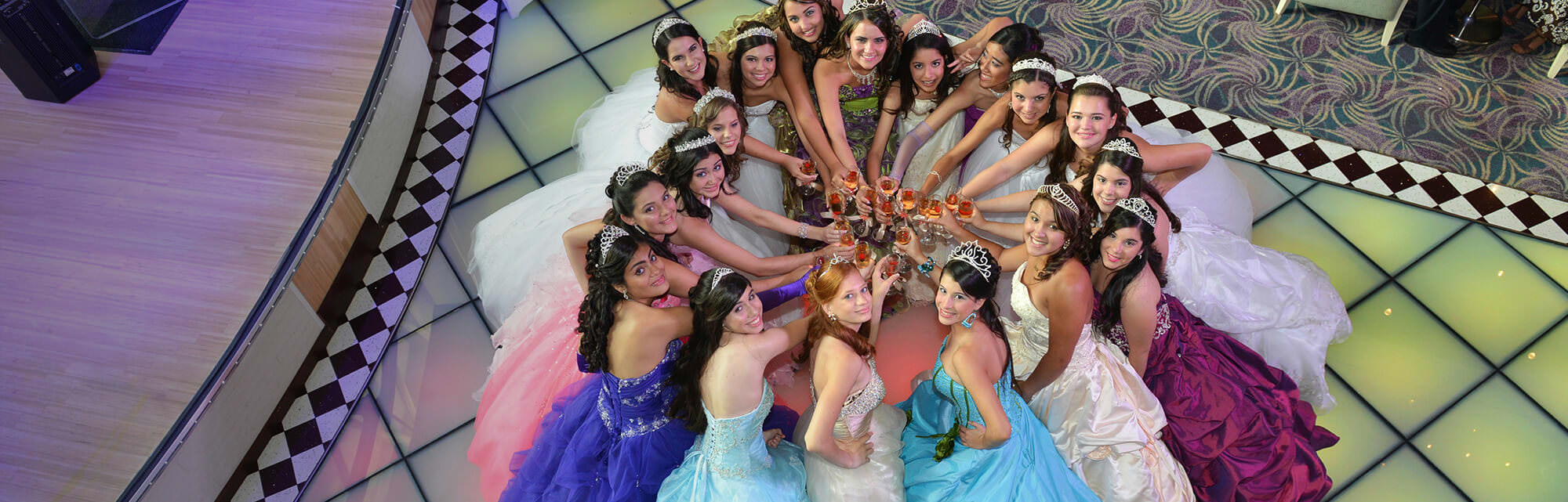 Quinceañeras raising a toast in gala dresses