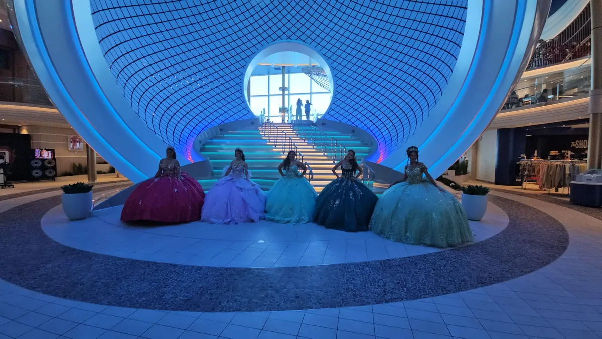 Quinceañeras posing in gala dresses inside the ship