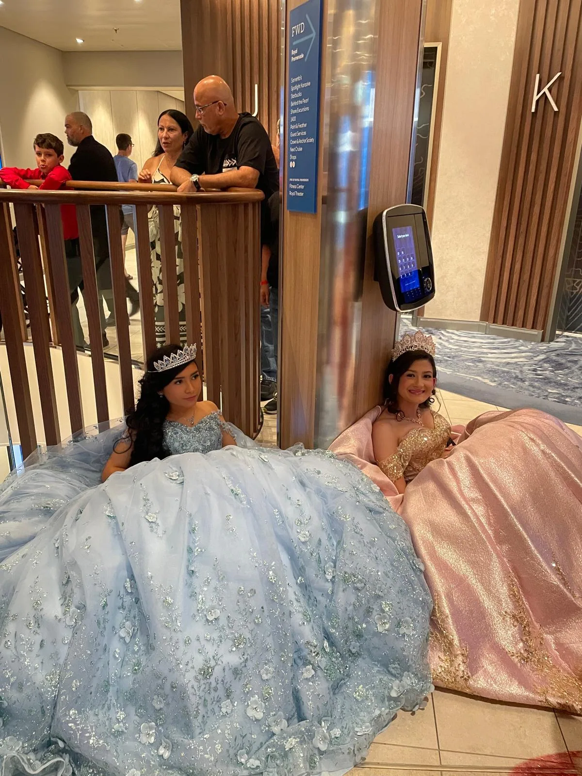 Quinceañeras in gala dresses beside the ship's staircase