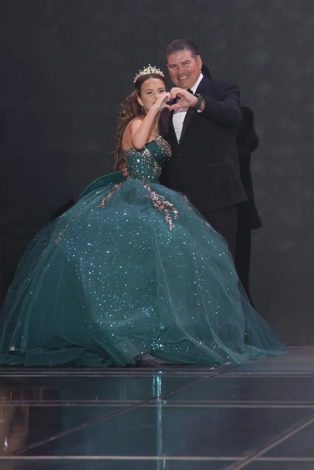 A quinceañera sharing a gala dance with her family