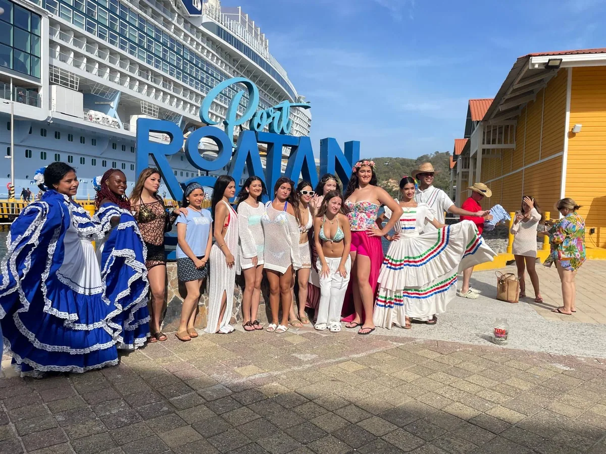 Travel Angels friends posing beside the Roatan sign