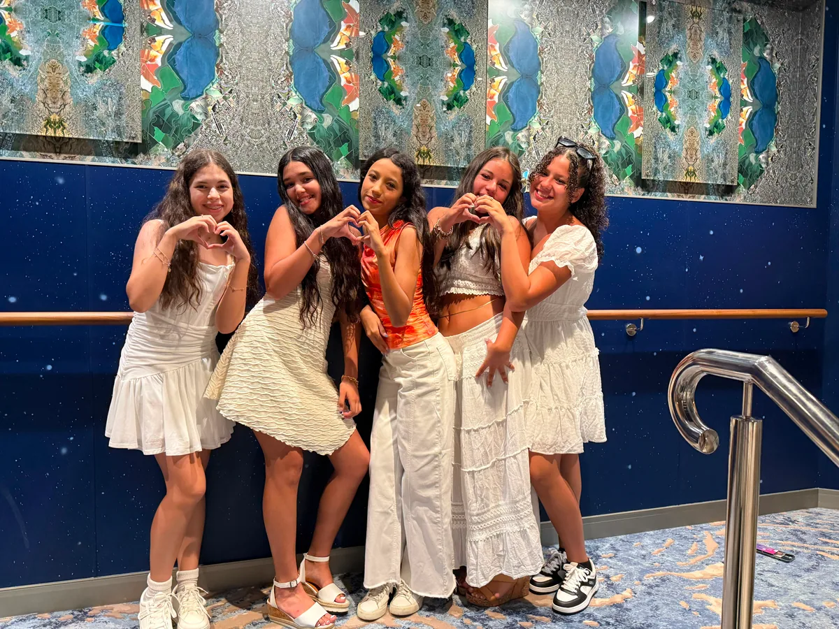 Friends smiling together beside a colorful mural