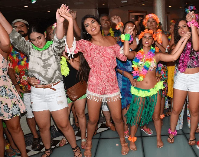 Guests dancing together in colorful outfits at the Travel Angels farewell party