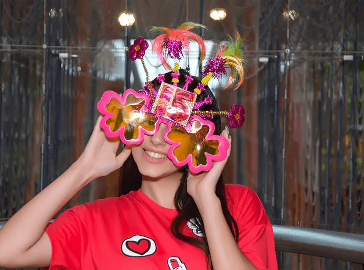 A quinceañera wearing festive glasses at the Travel Angels welcome party