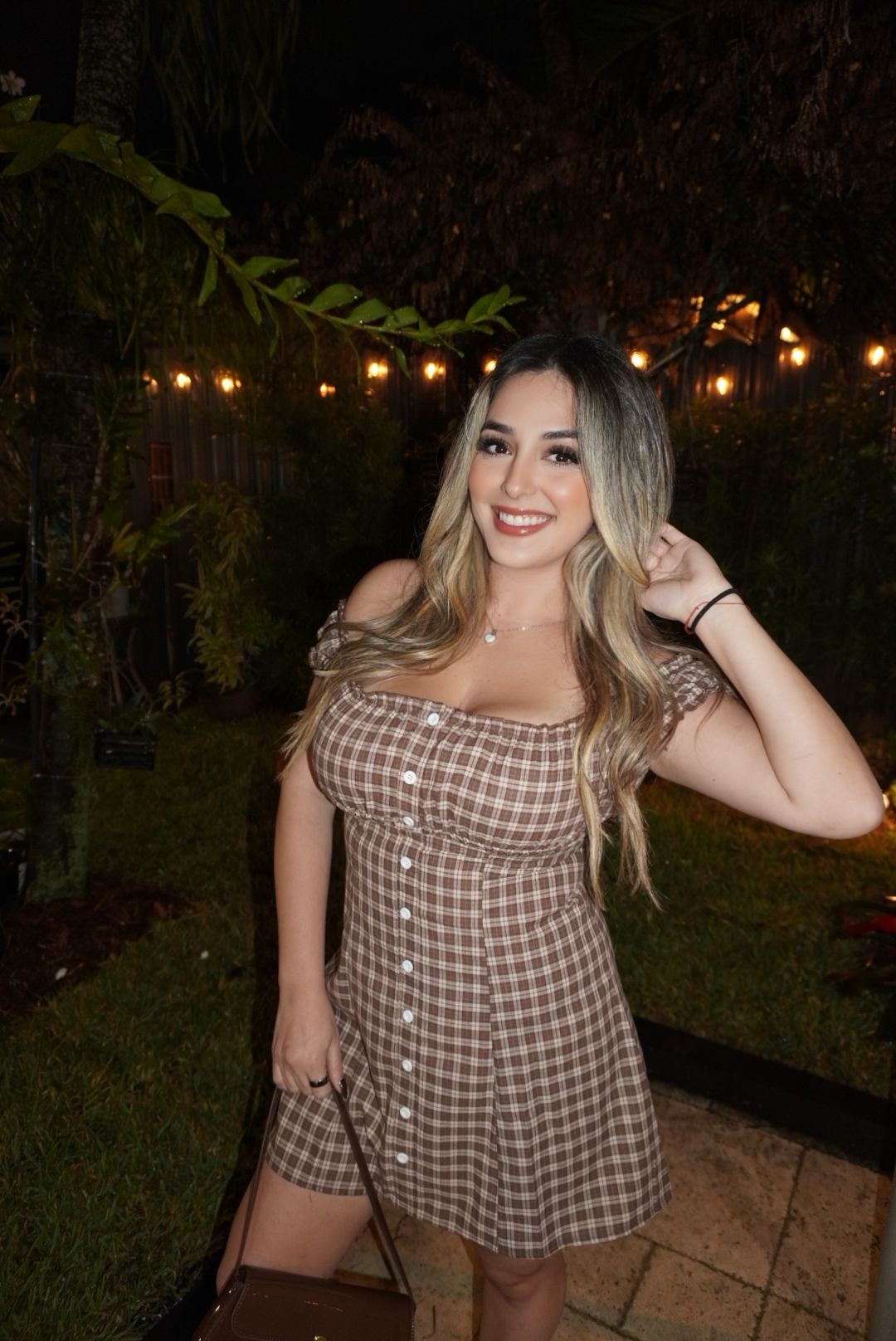 Wearing a brown checked dress at an outdoor evening event.